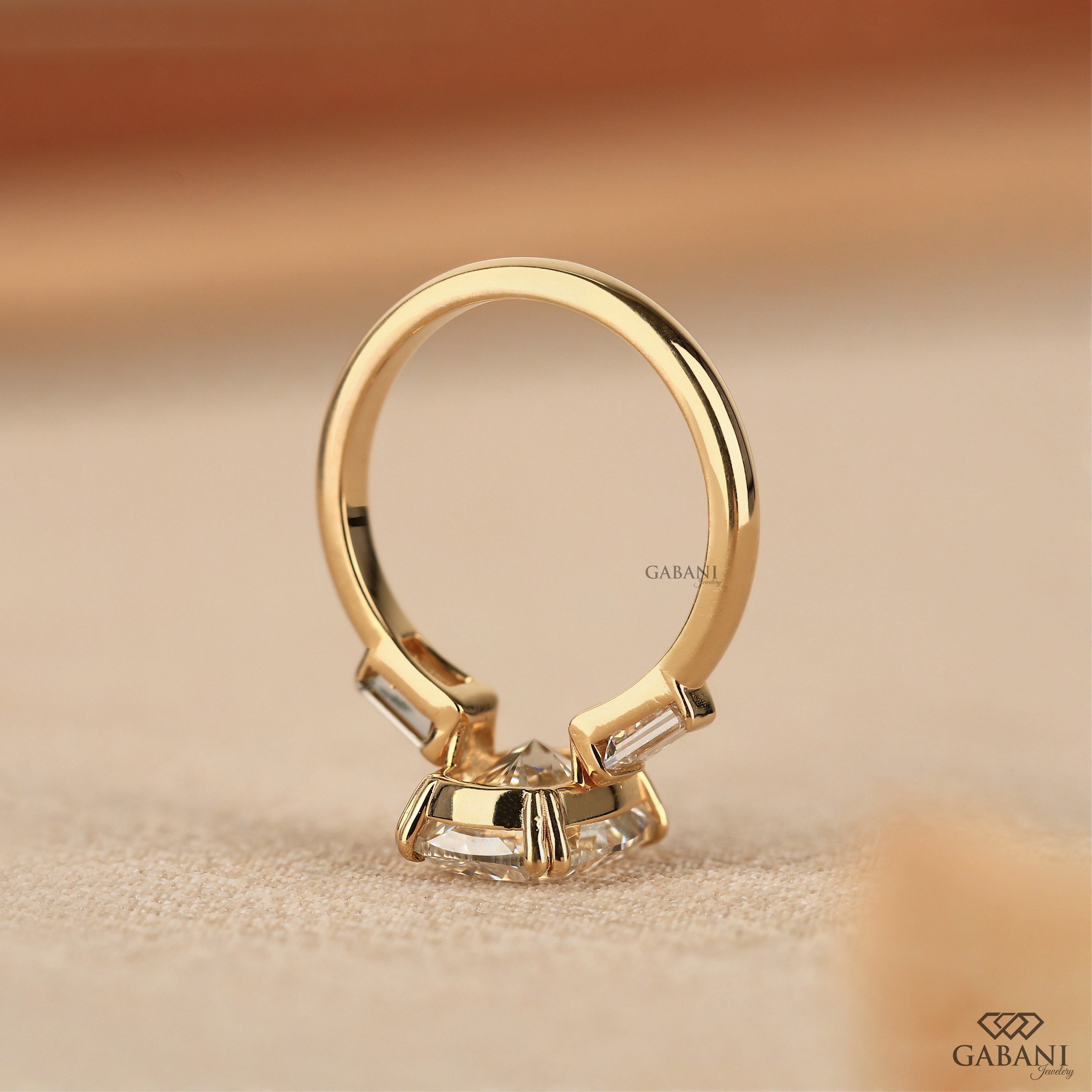 Top view of 14K yellow gold elongated cushion three stone ring