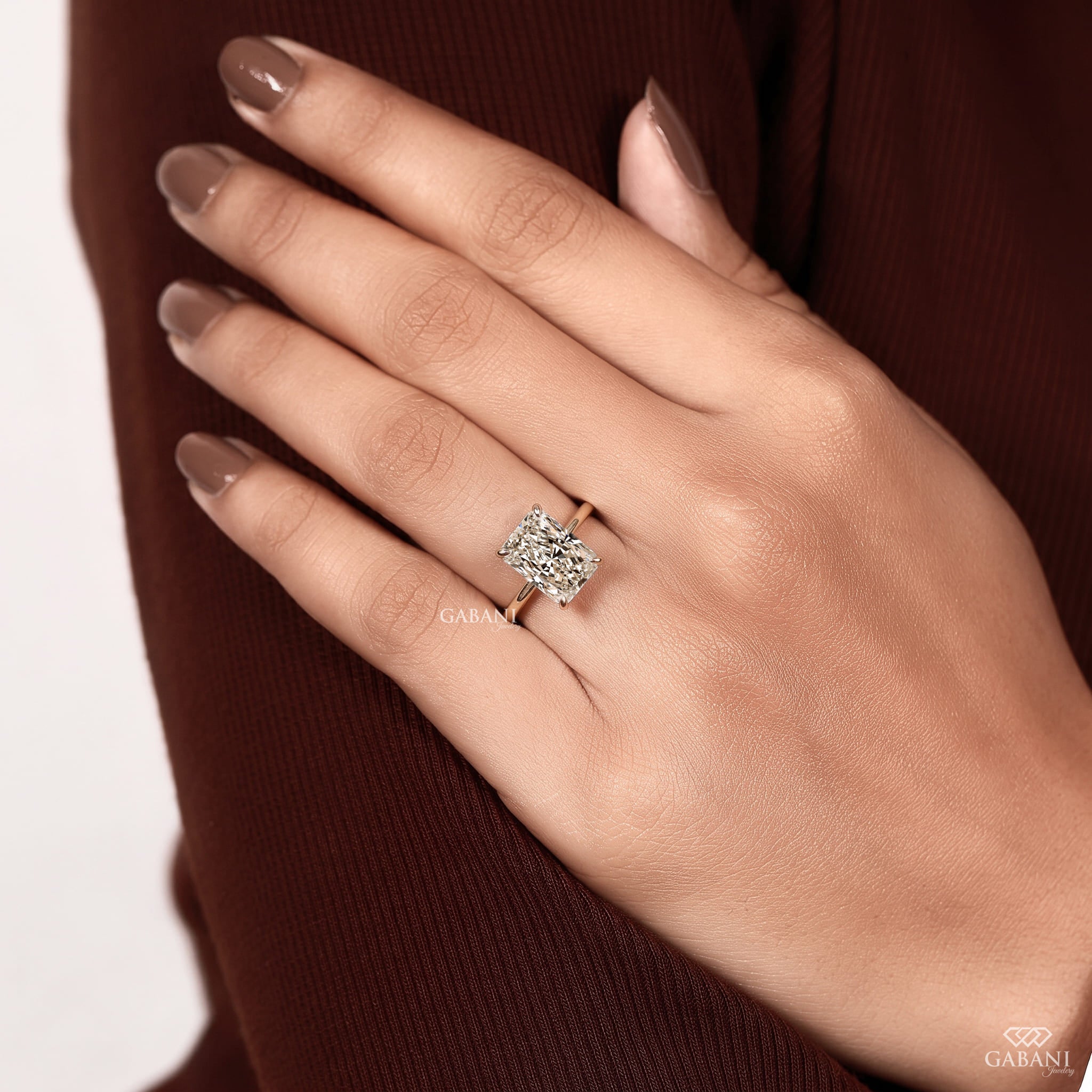 Radiant cut lab grown diamond engagement ring in 18K yellow gold with hidden halo, four claw prong setting and round diamond accents.