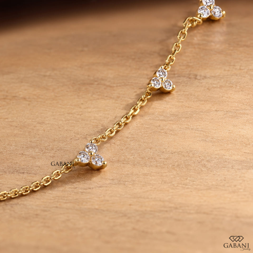 18K yellow gold lab grown diamond station necklace featuring round cut three stone floral clusters on a delicate gold chain.
