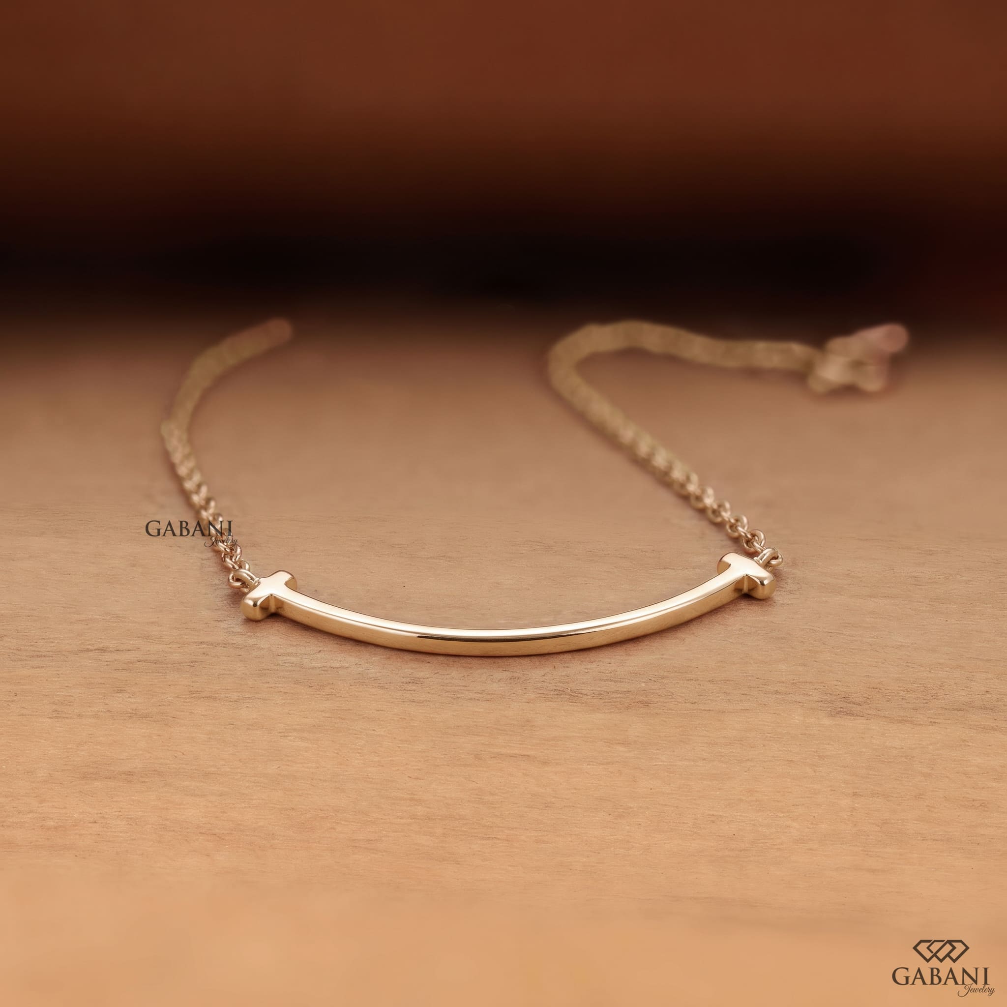 Curved bar lab grown diamond necklace in yellow gold featuring round pavé set diamonds, T-shaped ends and a delicate gold chain.