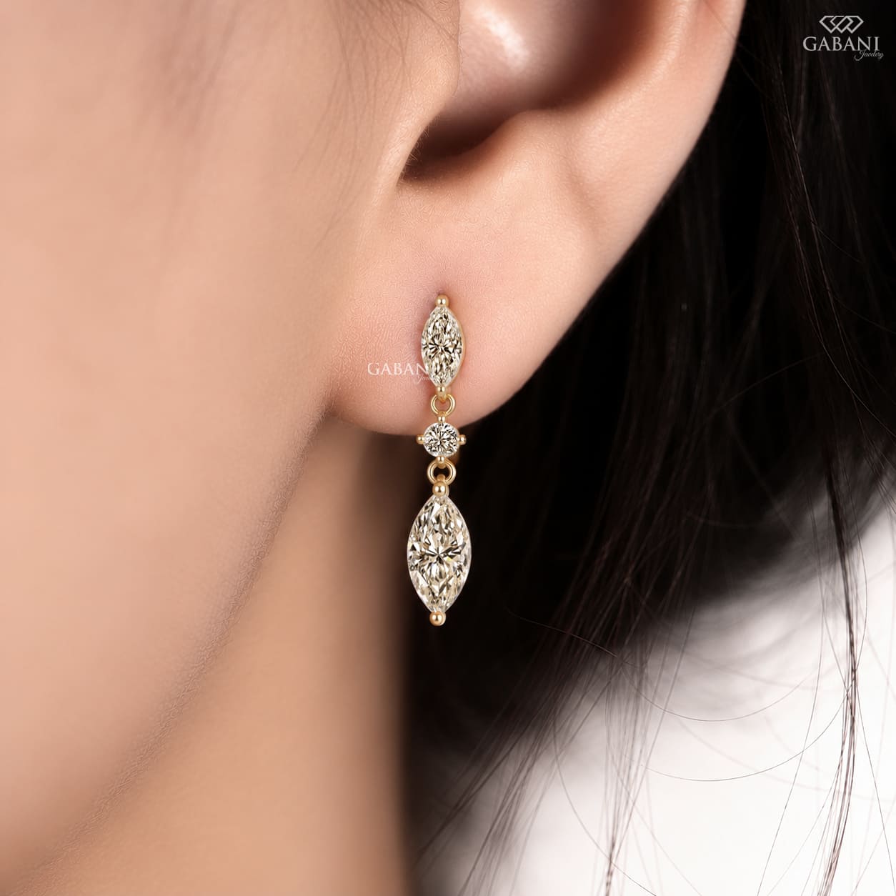 marquise and round cut lab grown diamond drop earrings in yellow gold, featuring two sparkling marquise diamonds connected by a round brilliant diamond on each earring, creating an elegant three-stone design by Gabani Jewelry.