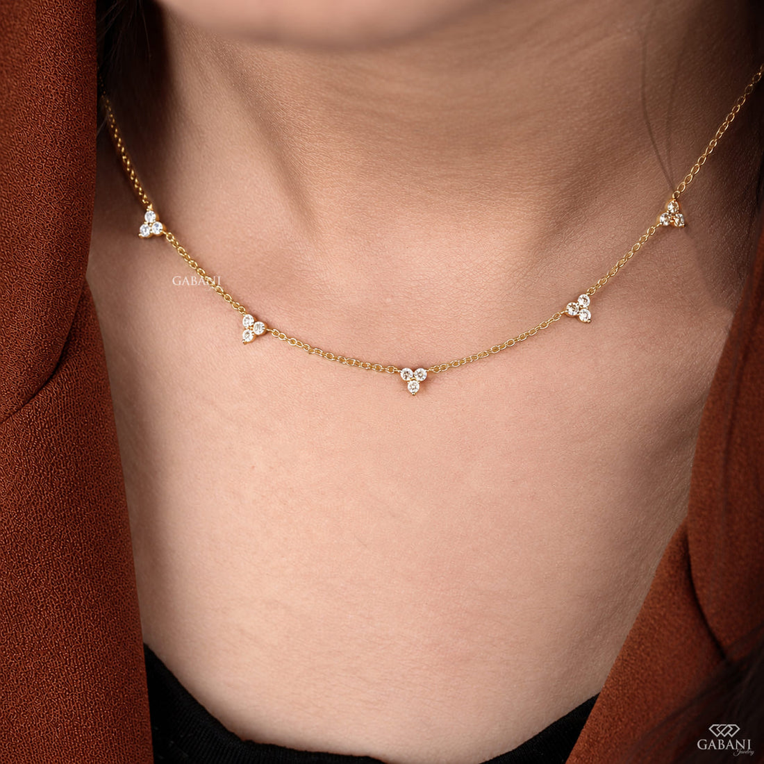 18K yellow gold lab grown diamond station necklace featuring round cut three stone floral clusters on a delicate gold chain.