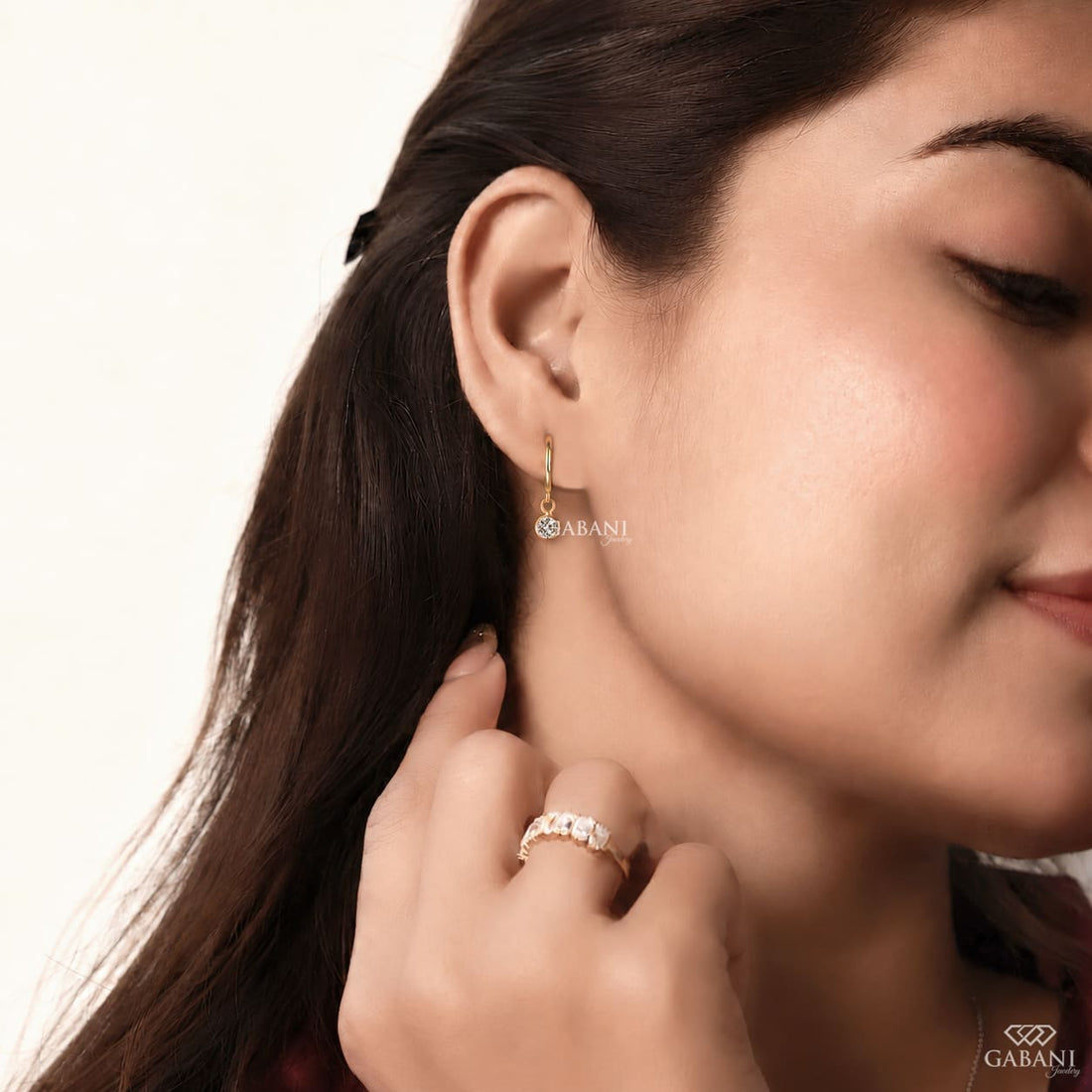 Round lab grown diamond bezel drop huggie earrings in yellow gold with 5 mm diamonds and hinged hoop closure.