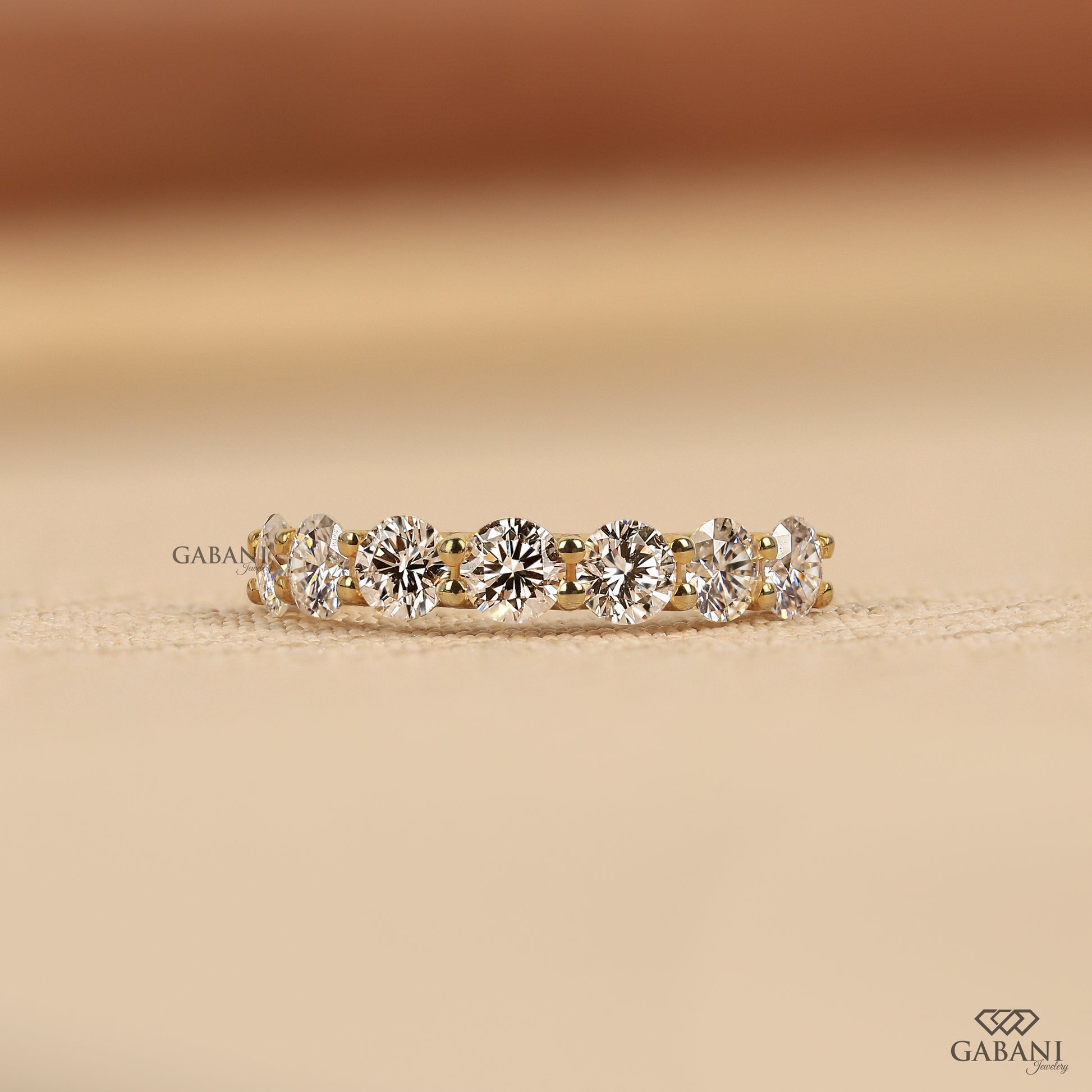 7 stone lab grown diamond wedding band with round cut diamonds in a U prong setting crafted in 14k yellow gold