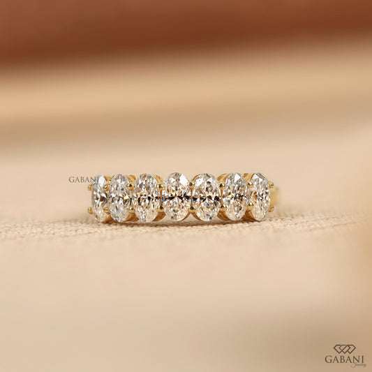 seven stone lab grown diamond band in 14k yellow gold with oval diamonds and half eternity design