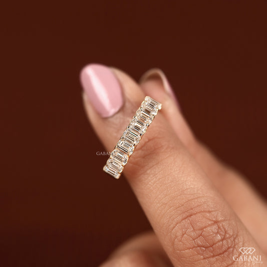 yellow gold wedding band with emerald cut lab diamond stones in half eternity u prong setting

