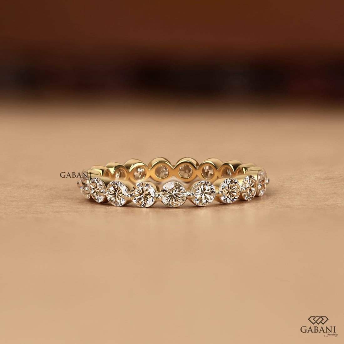 Round cut lab grown diamond full eternity wedding band in yellow gold with shared prong setting.