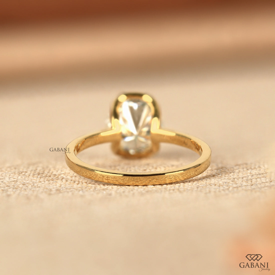 Round diamond half bezel solitaire engagement ring in yellow gold with a slim straight polished band.