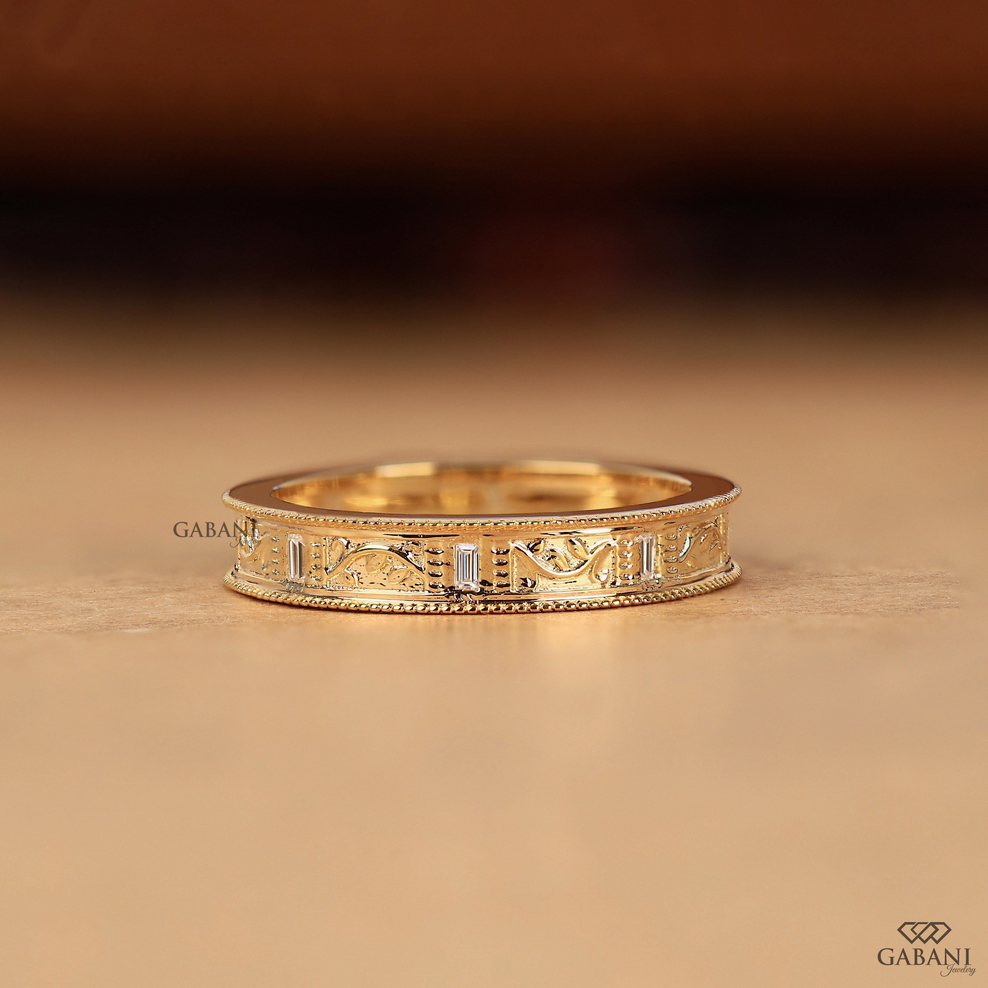 Baguette cut lab grown diamond wedding band with vintage floral engraving, milgrain edges, and polished yellow gold finish.