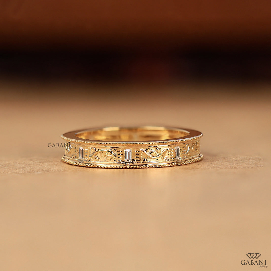 Baguette cut lab grown diamond wedding band with vintage floral engraving, milgrain edges, and polished yellow gold finish.