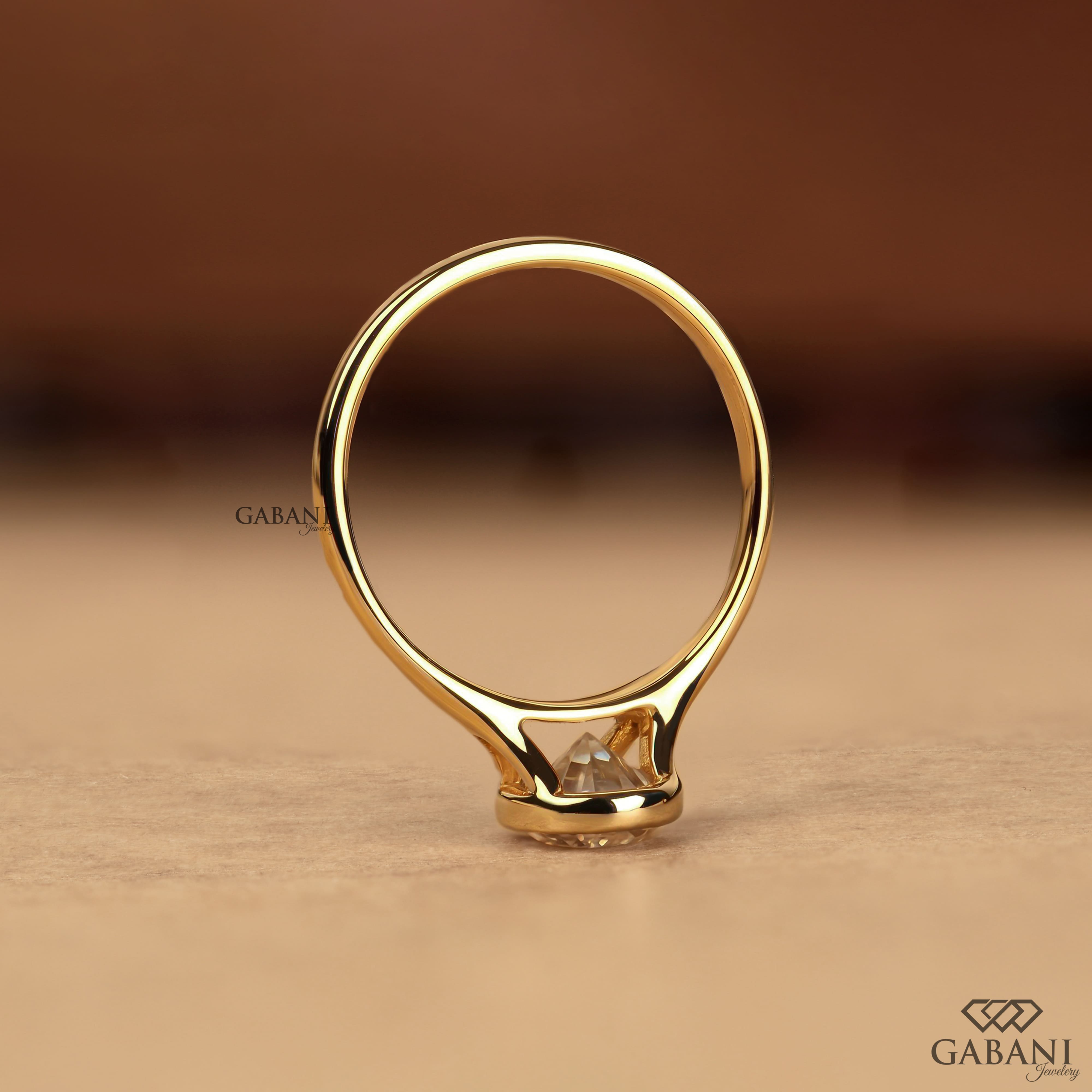 Pear cut diamond solitaire engagement ring with full bezel setting in polished yellow gold