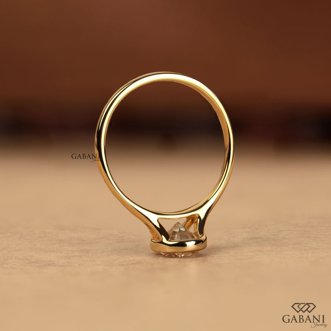 Pear cut diamond solitaire engagement ring with full bezel setting in polished yellow gold