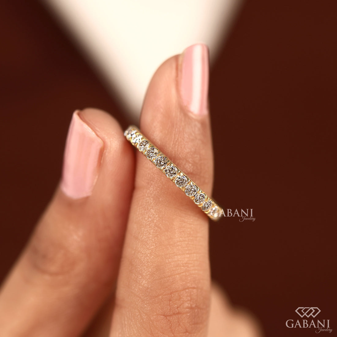 Round cut lab grown diamond eternity wedding band in yellow gold with continuous diamond setting and classic bridal style.
