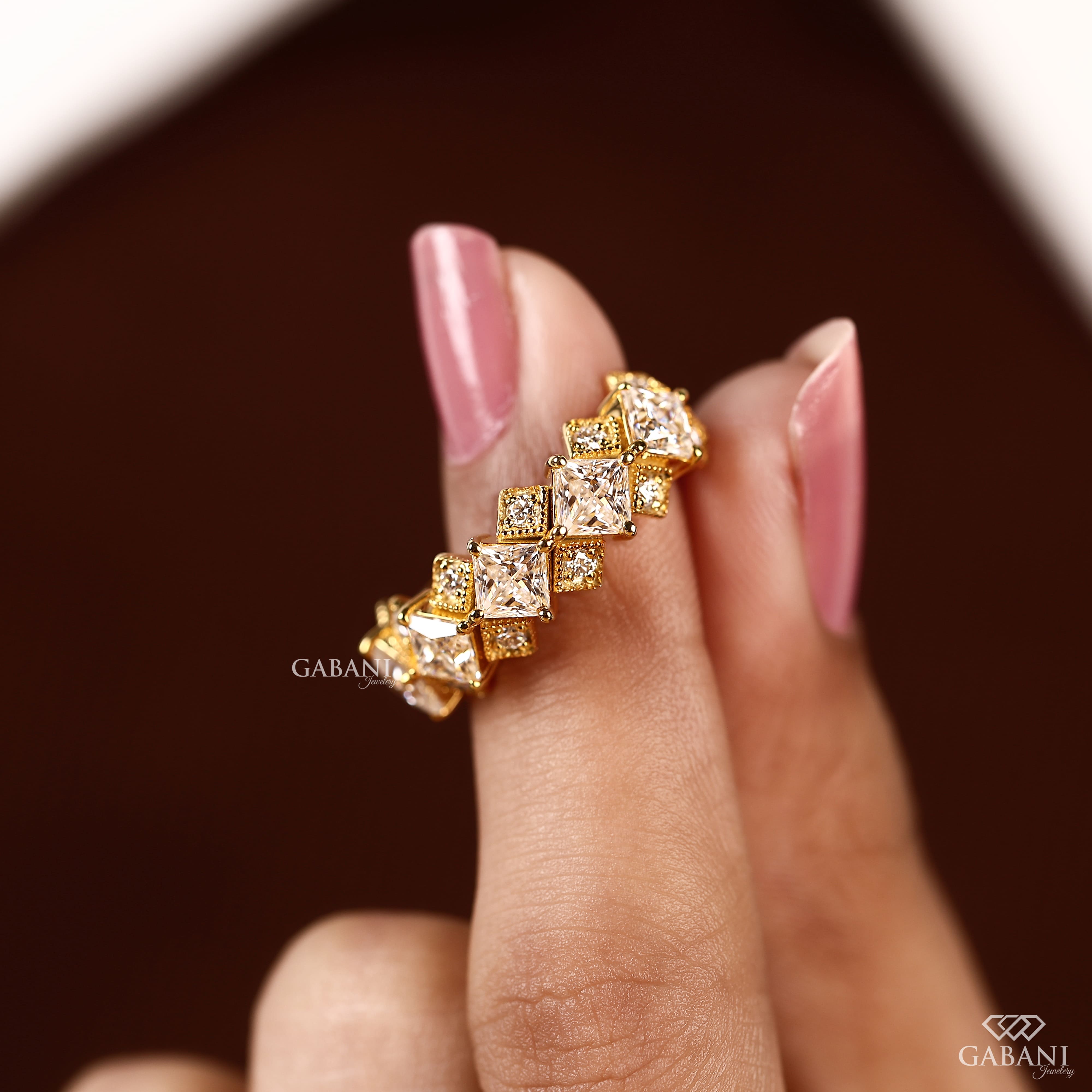 Princess cut lab grown diamond wedding band in yellow gold with round diamond accents and a geometric half eternity design for bridal and anniversary wear.