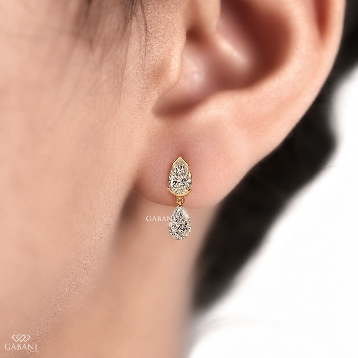 pear cut lab grown diamond drop earrings in yellow gold, featuring two sparkling pear-shaped diamonds on each earring in an elegant double teardrop design by Gabani Jewelry.