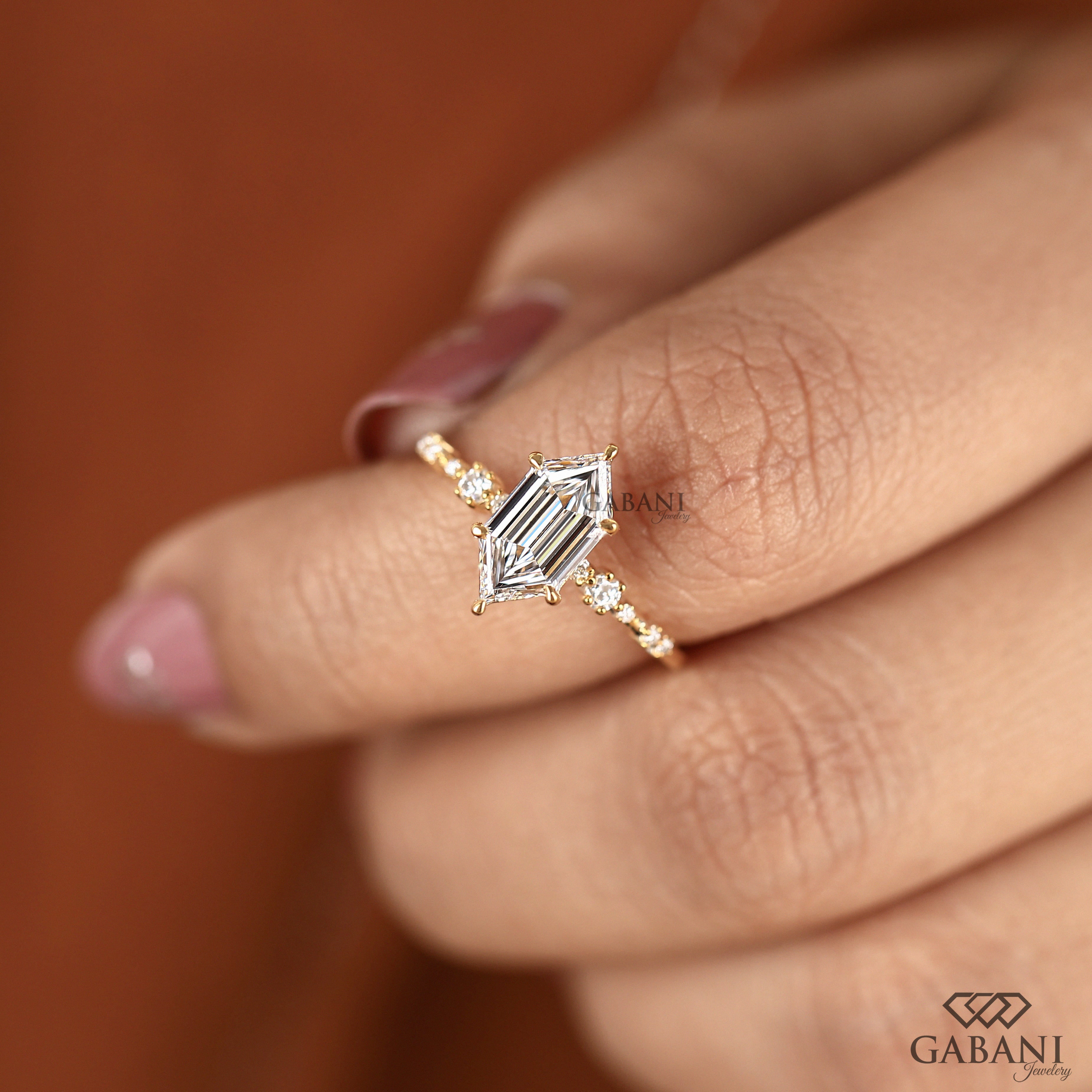 Dutch marquise lab grown diamond engagement ring with elongated geometric center stone, round side diamond accents and gold band.