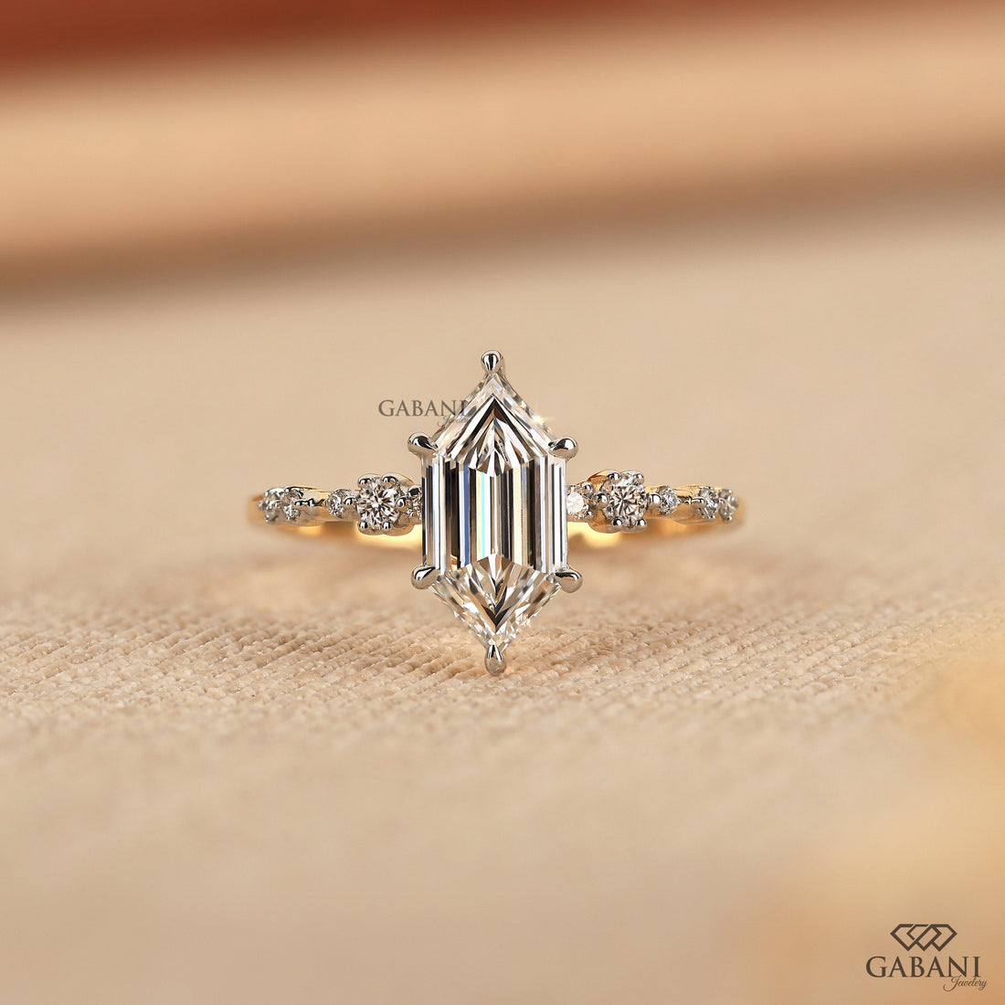 Dutch marquise lab grown diamond engagement ring with elongated geometric center stone, round side diamond accents and gold band.