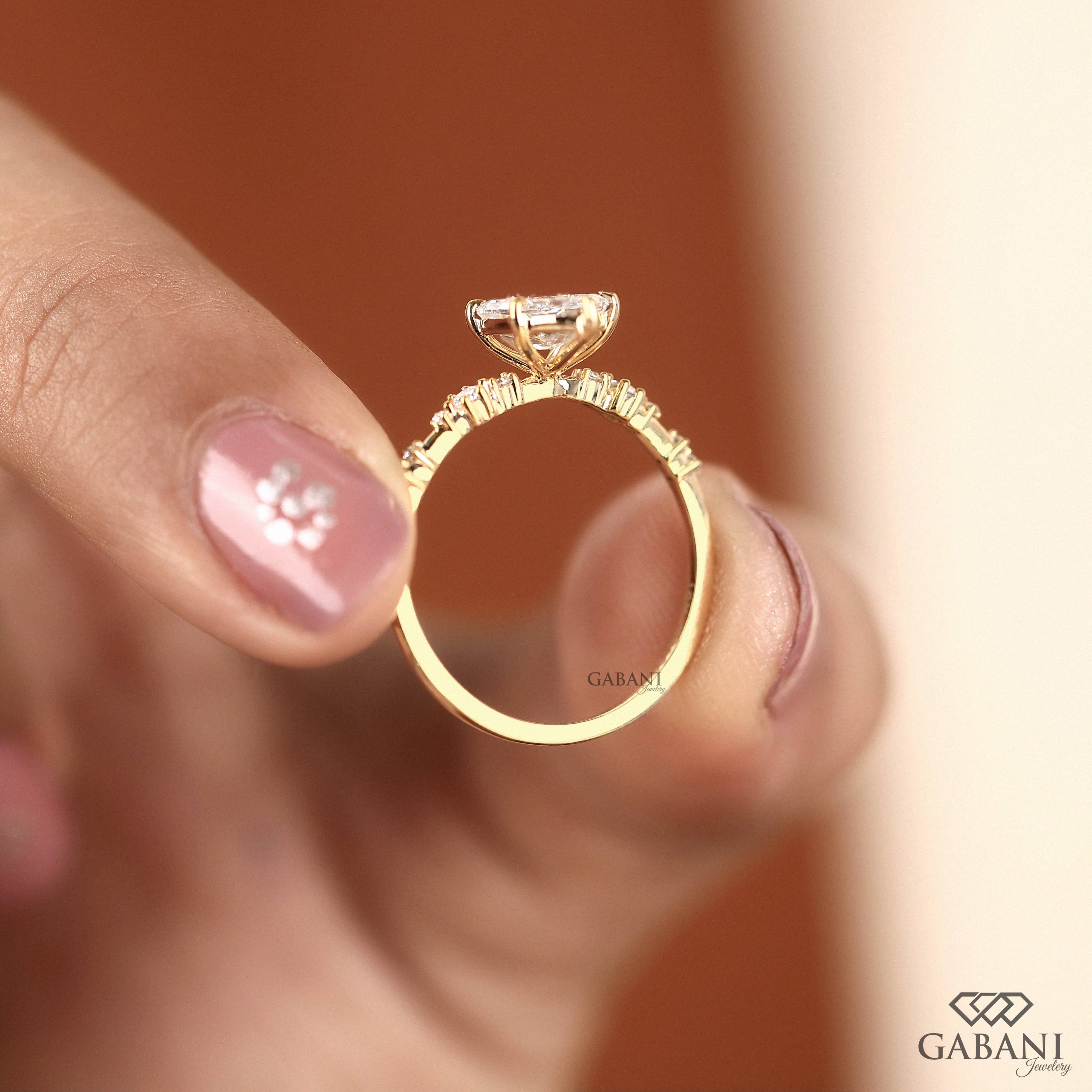 Dutch marquise lab grown diamond engagement ring with elongated geometric center stone, round side diamond accents and gold band.