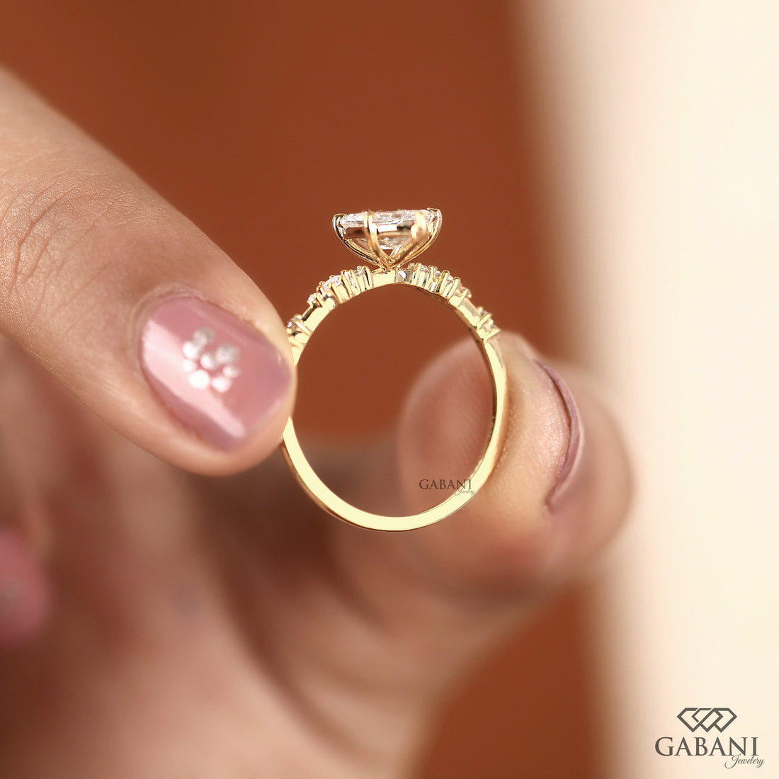 Dutch marquise lab grown diamond engagement ring with elongated geometric center stone, round side diamond accents and gold band.