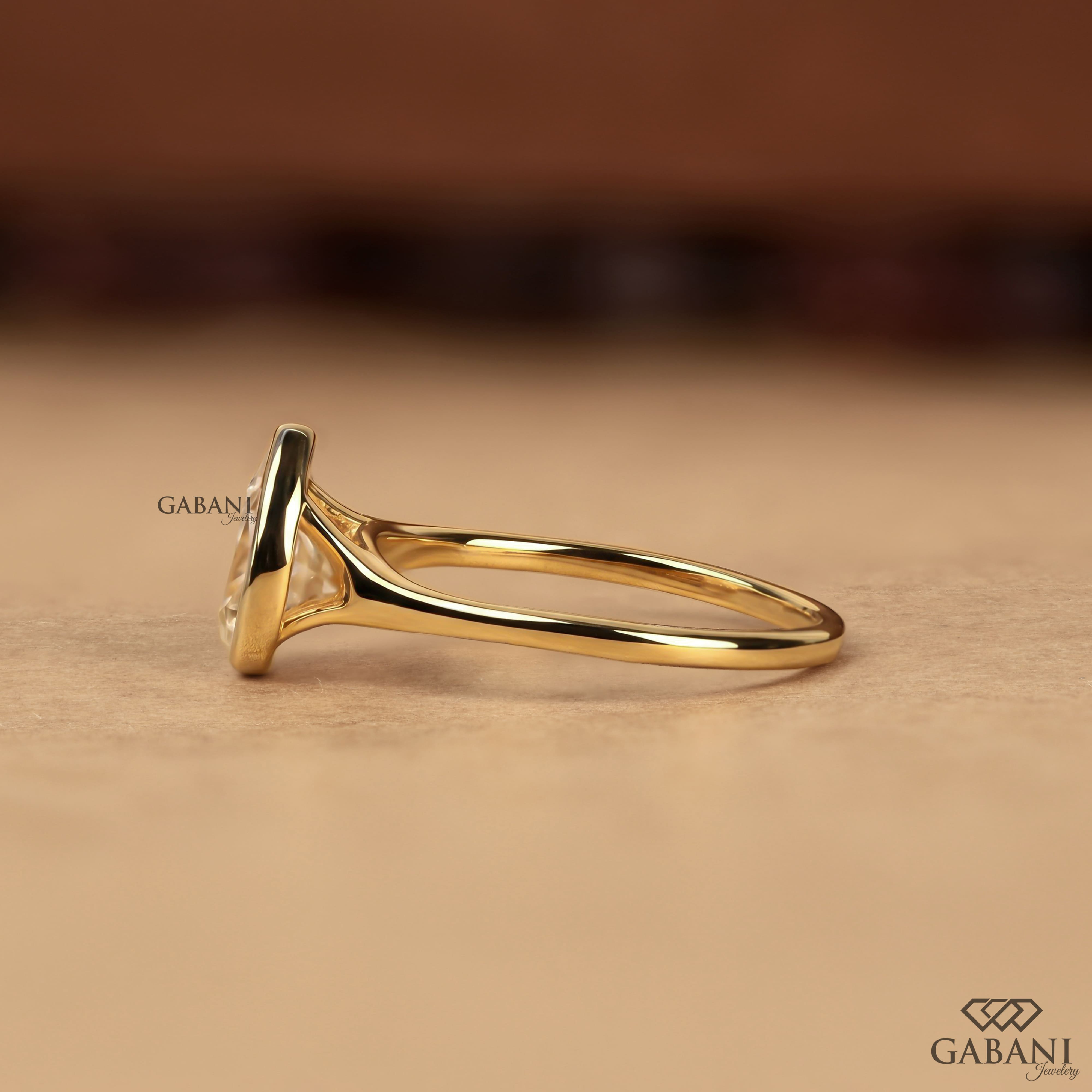 Pear cut diamond solitaire engagement ring with full bezel setting in polished yellow gold