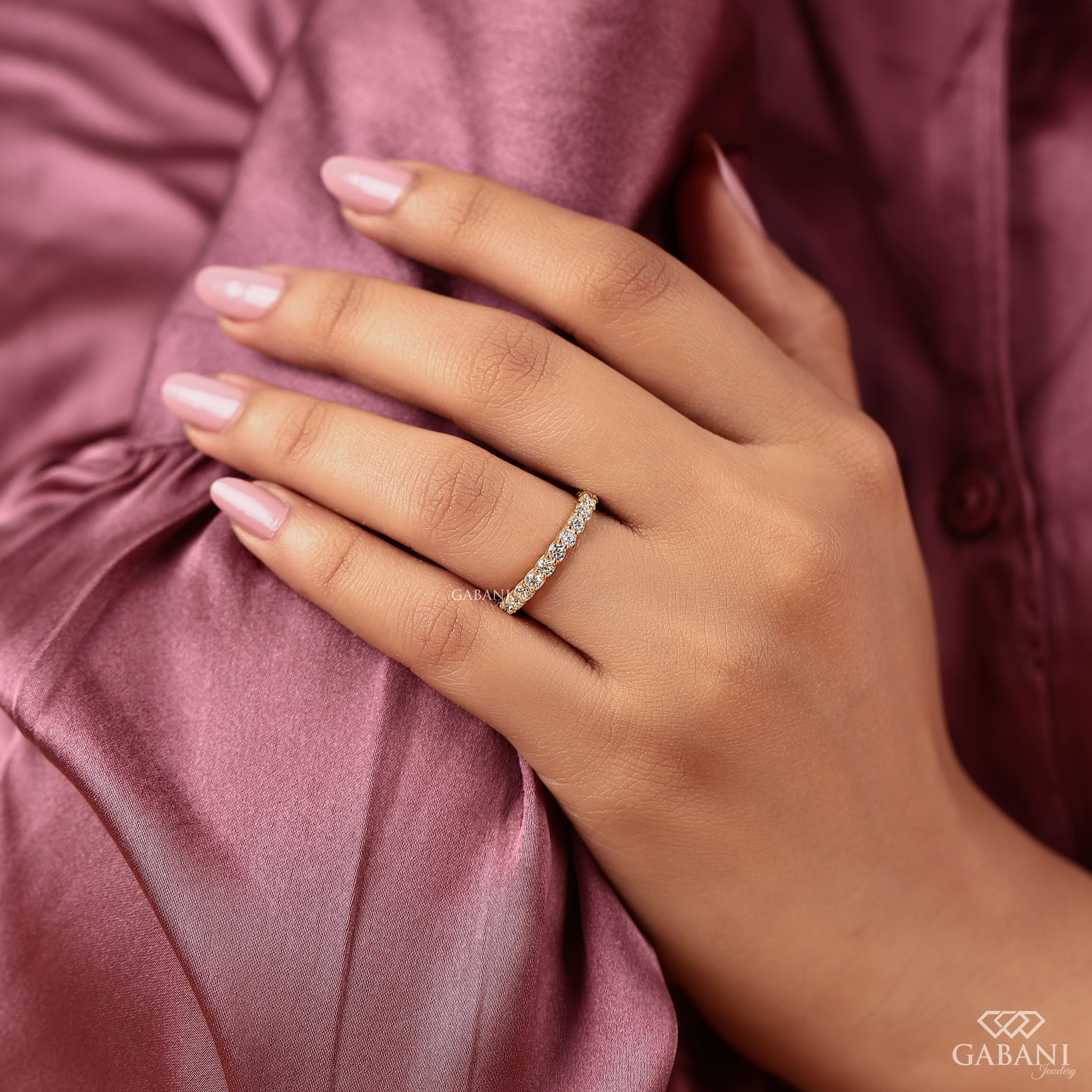 a round lab grown diamond full eternity band in 14K yellow gold, featuring sparkling shared prong set diamonds in a classic wedding band design by Gabani Jewelry.