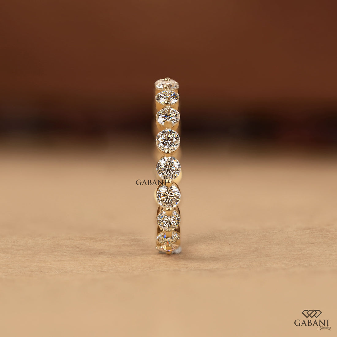 Round cut lab grown diamond full eternity wedding band in yellow gold with shared prong setting.