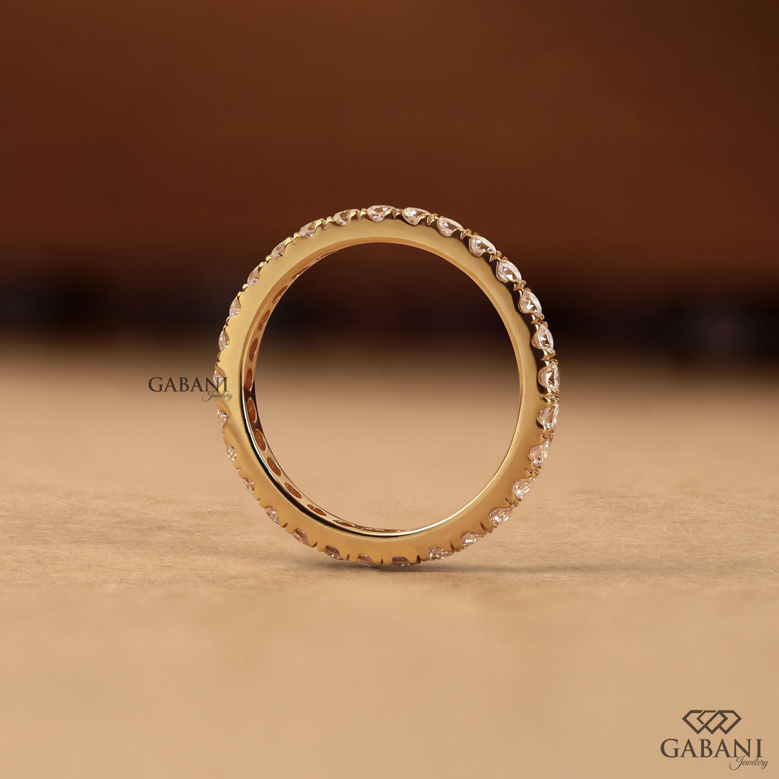Round cut lab grown diamond eternity wedding band in yellow gold with continuous diamond setting and classic bridal style.