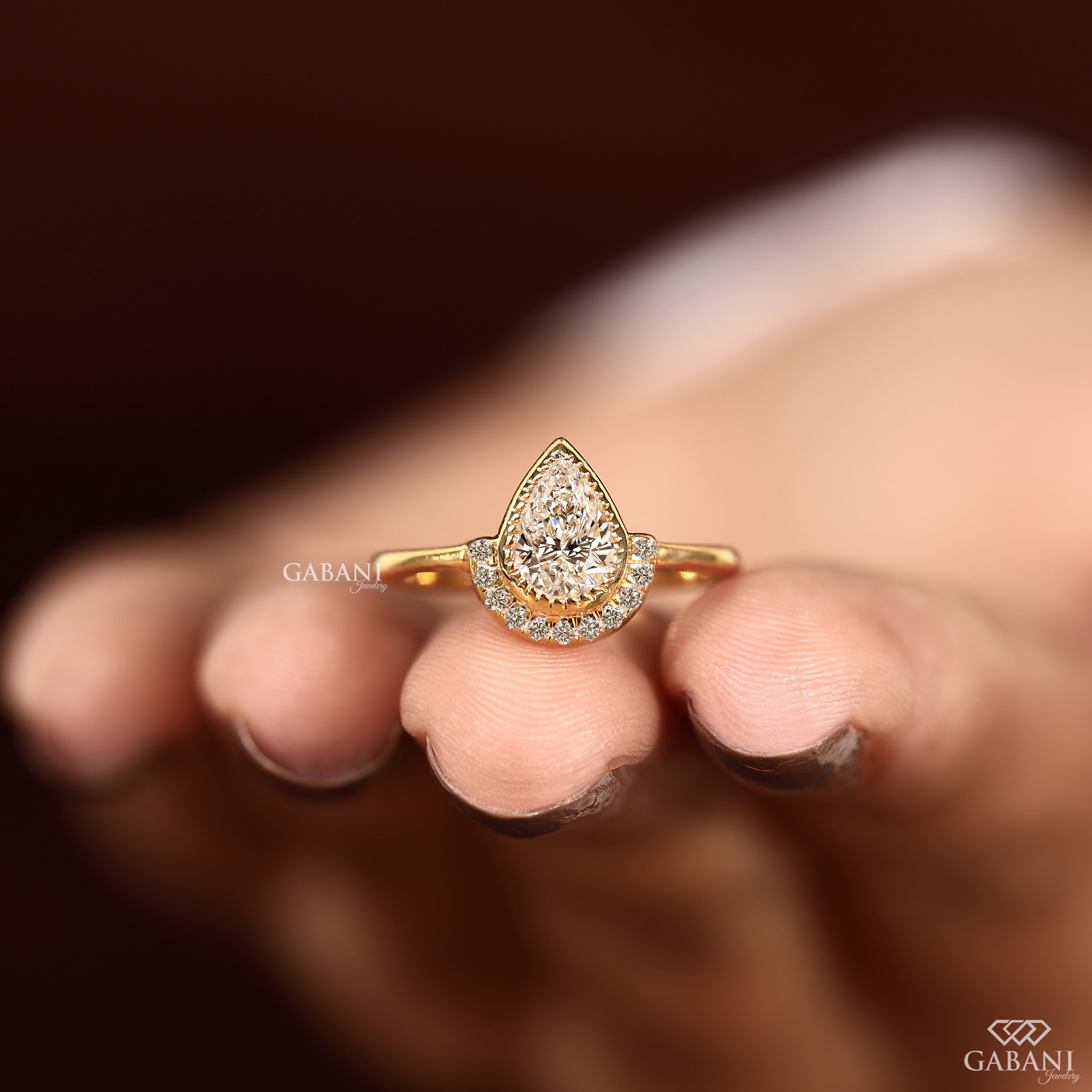 Bezel set pear cut lab grown diamond ring with yellow gold band