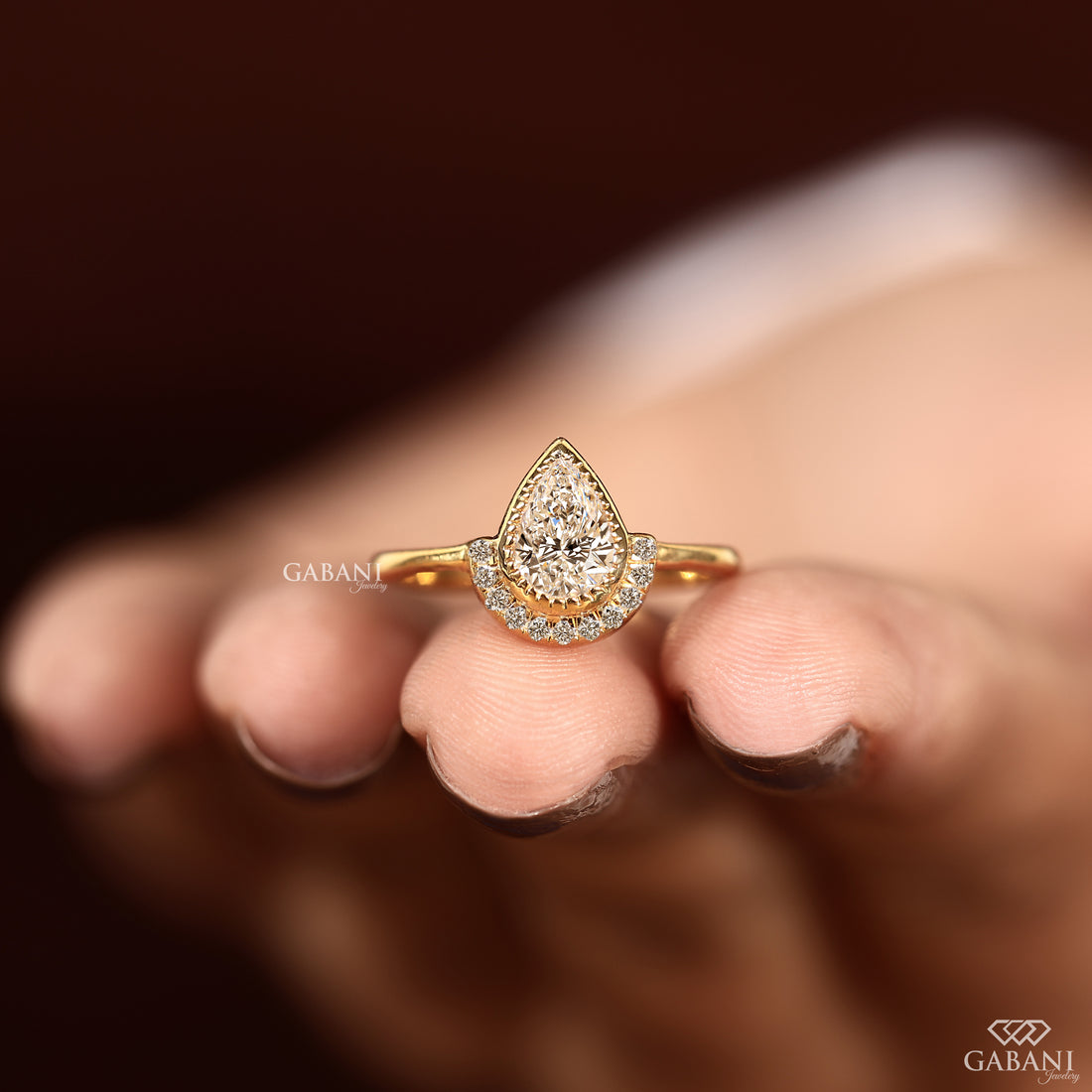 Bezel set pear cut lab grown diamond ring with yellow gold band