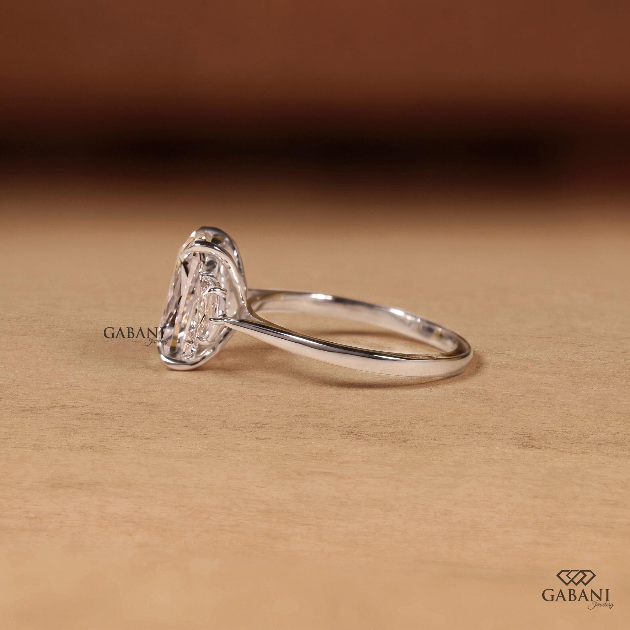 Cushion cut lab grown diamond three stone engagement ring with pear cut side diamonds in gold setting