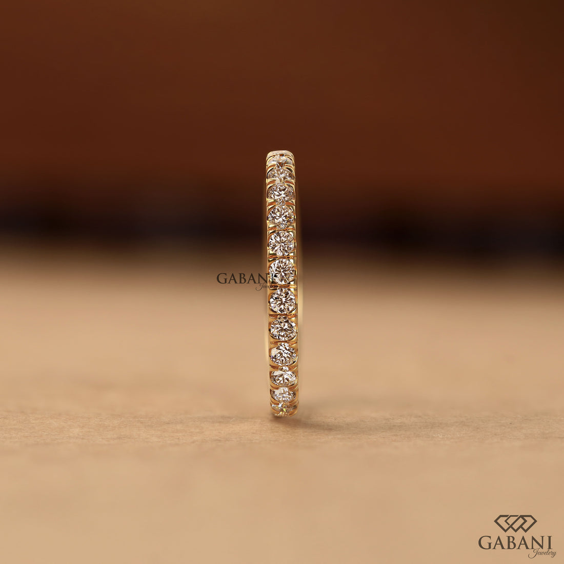 Round cut lab grown diamond eternity wedding band in yellow gold with continuous diamond setting and classic bridal style.