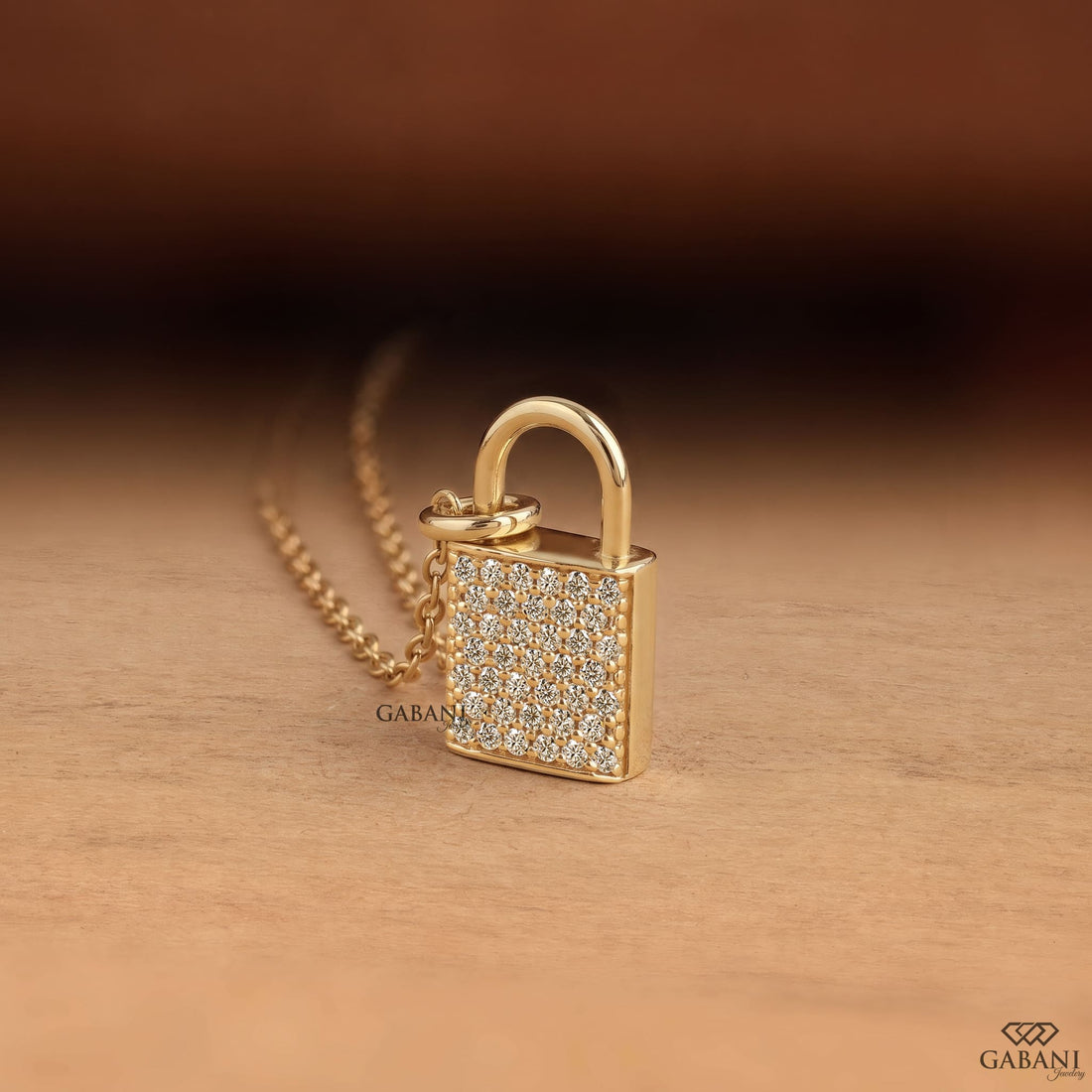 Yellow gold padlock pendant necklace featuring rows of round cut lab grown diamonds in a pavé setting with a polished gold shackle.