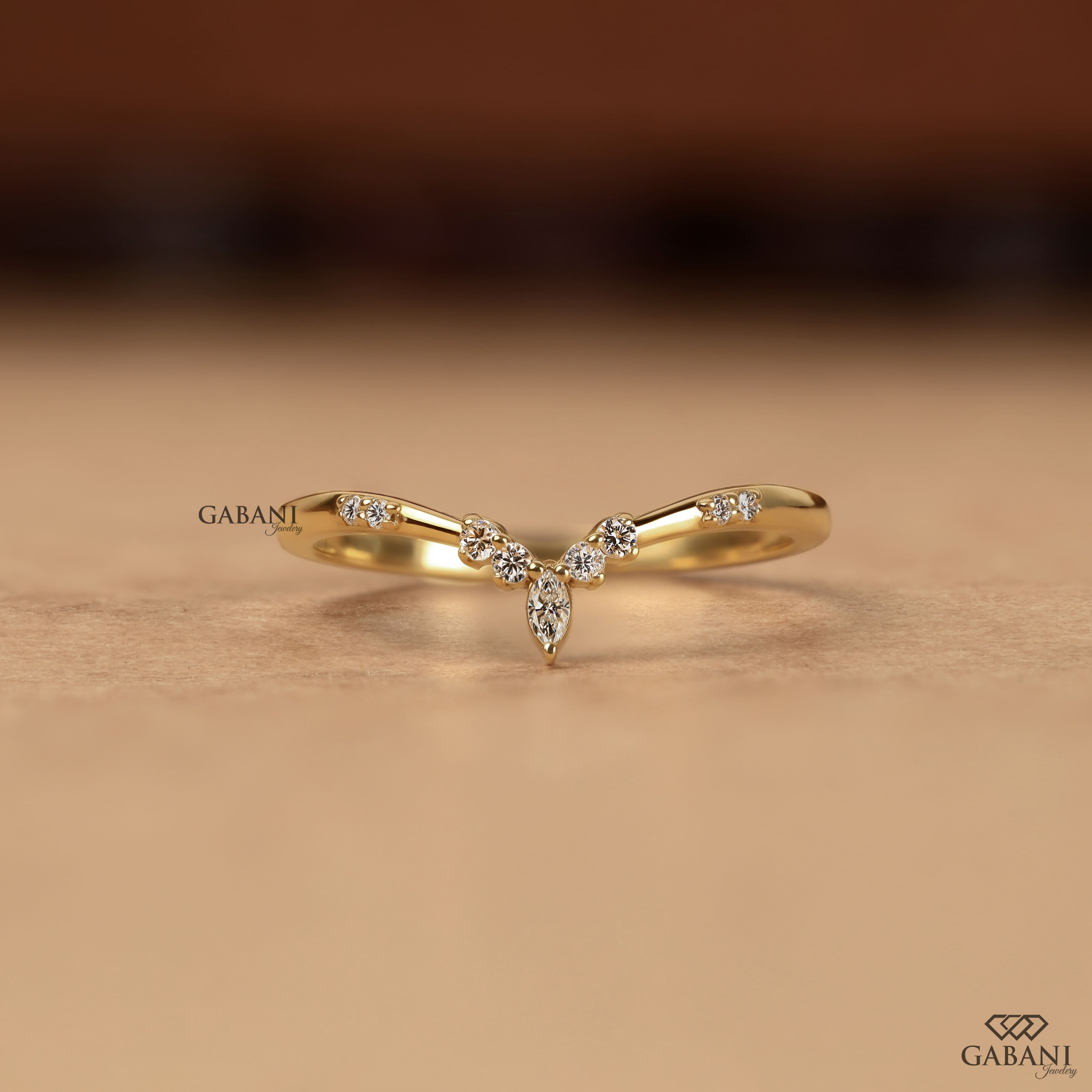Marquise and round cut lab grown diamond curved wedding band in yellow gold with V shaped contour design for stacking with an engagement ring.