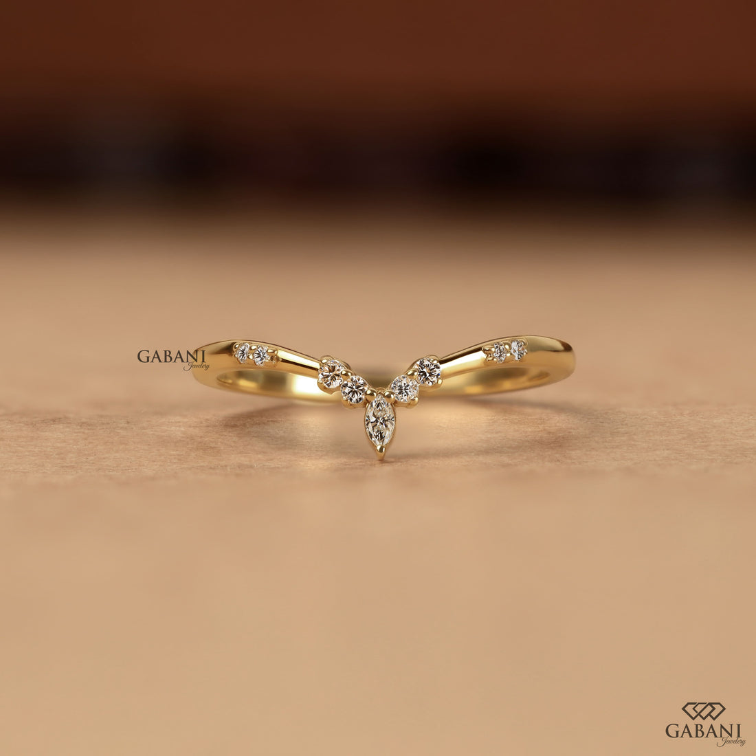 Marquise and round cut lab grown diamond curved wedding band in yellow gold with V shaped contour design for stacking with an engagement ring.