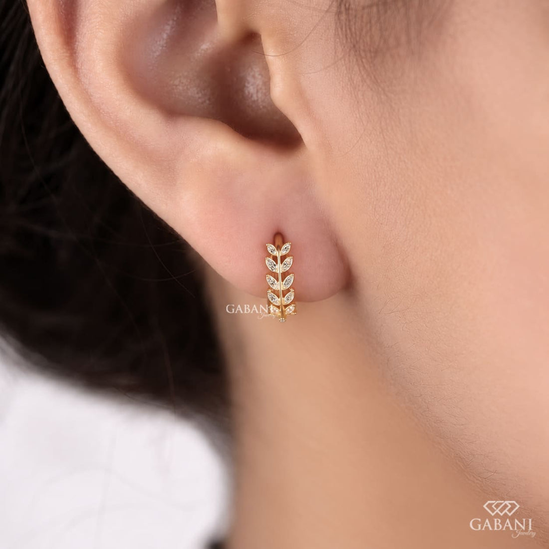Marquise diamond leaf huggie earrings in yellow gold with a nature inspired vine design and marquise cut diamond leaves.