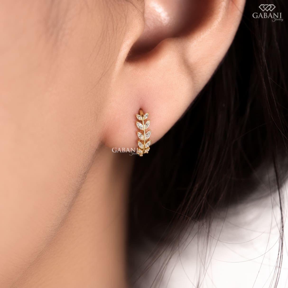 Marquise diamond leaf huggie earrings in yellow gold with a nature inspired vine design and marquise cut diamond leaves.