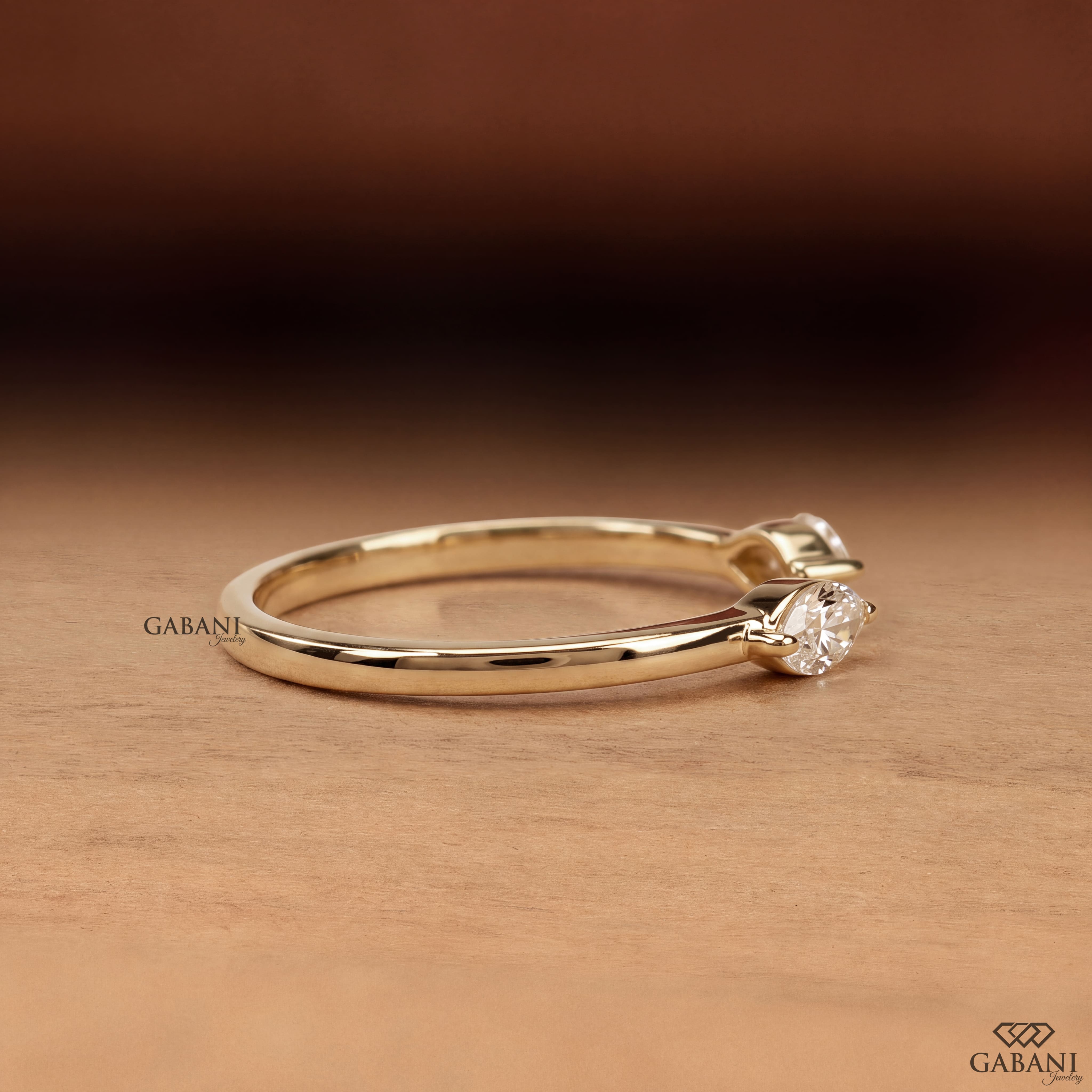 a marquise cut lab grown diamond open cuff ring in 14K yellow gold, featuring two horizontally set marquise diamonds in elegant half bezel settings with a modern minimalist design by Gabani Jewelry.