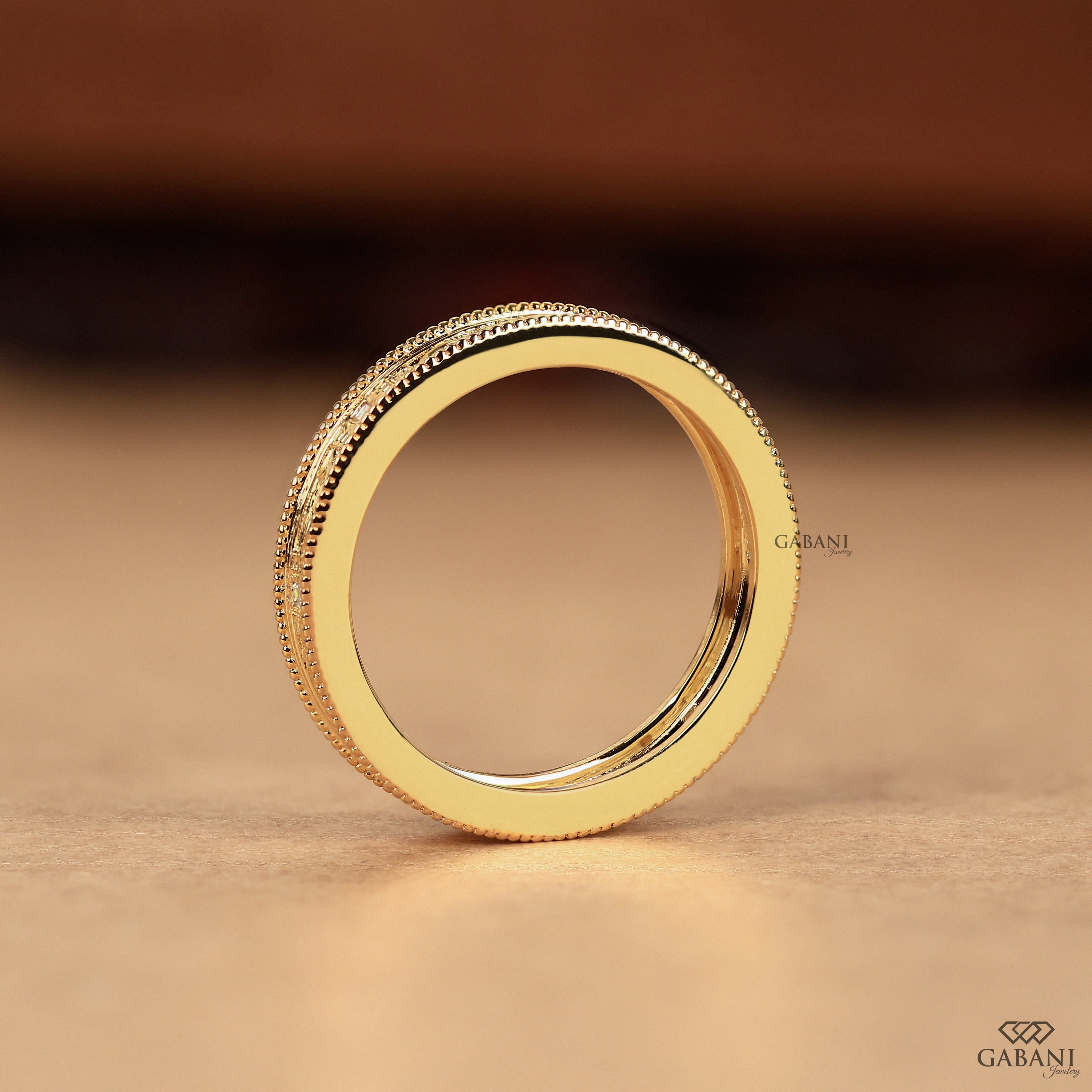 Baguette cut lab grown diamond wedding band with vintage floral engraving, milgrain edges, and polished yellow gold finish.