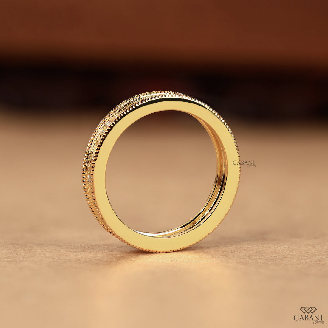 Baguette cut lab grown diamond wedding band with vintage floral engraving, milgrain edges, and polished yellow gold finish.