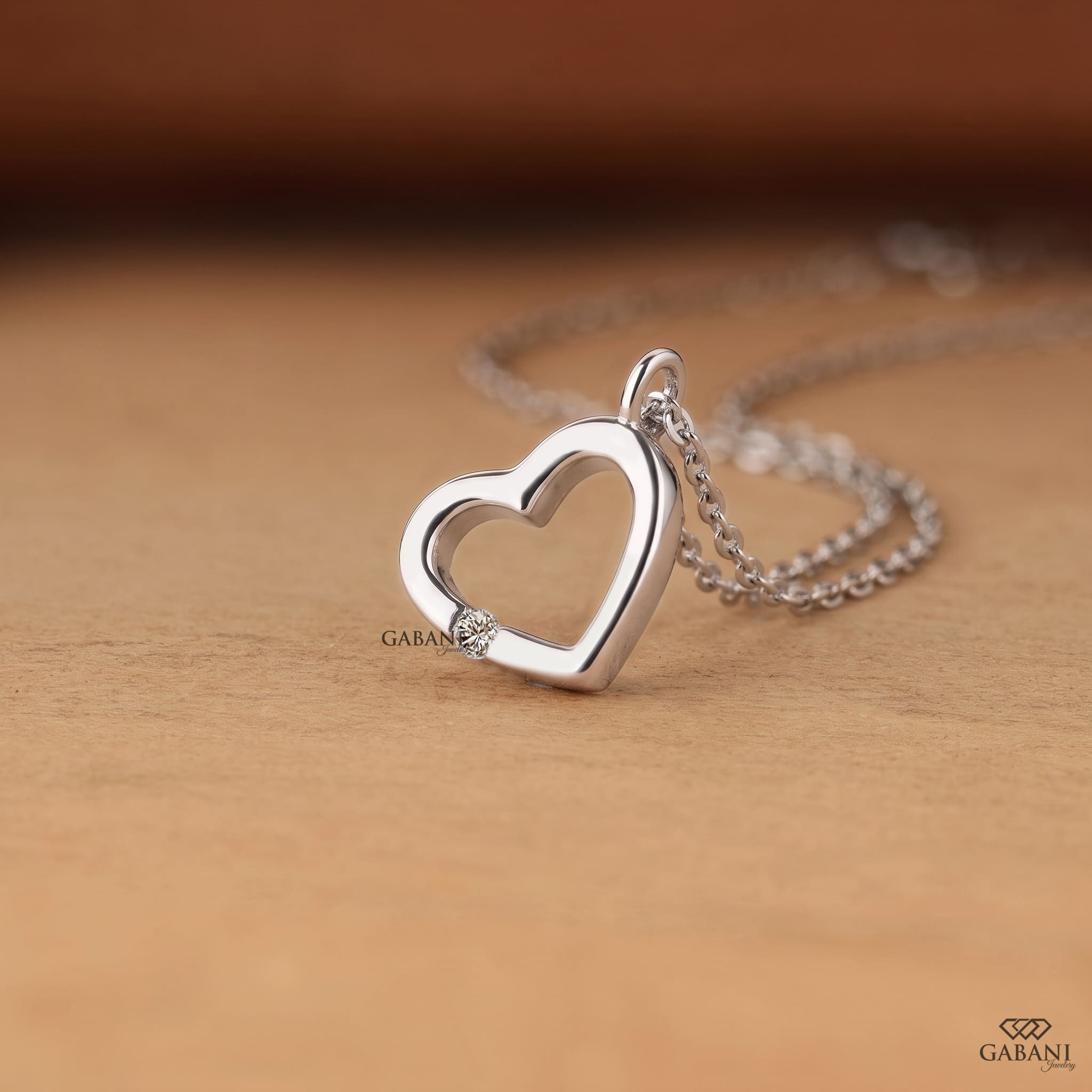 Open heart lab grown diamond pendant necklace in polished white gold featuring a single round cut diamond accent and delicate link chain.