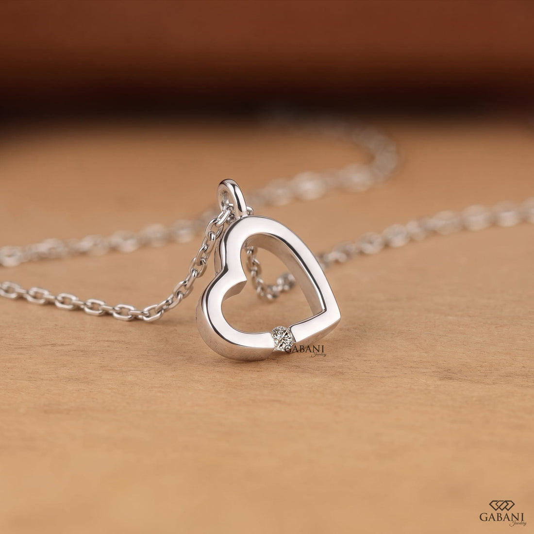 Open heart lab grown diamond pendant necklace in polished white gold featuring a single round cut diamond accent and delicate link chain.