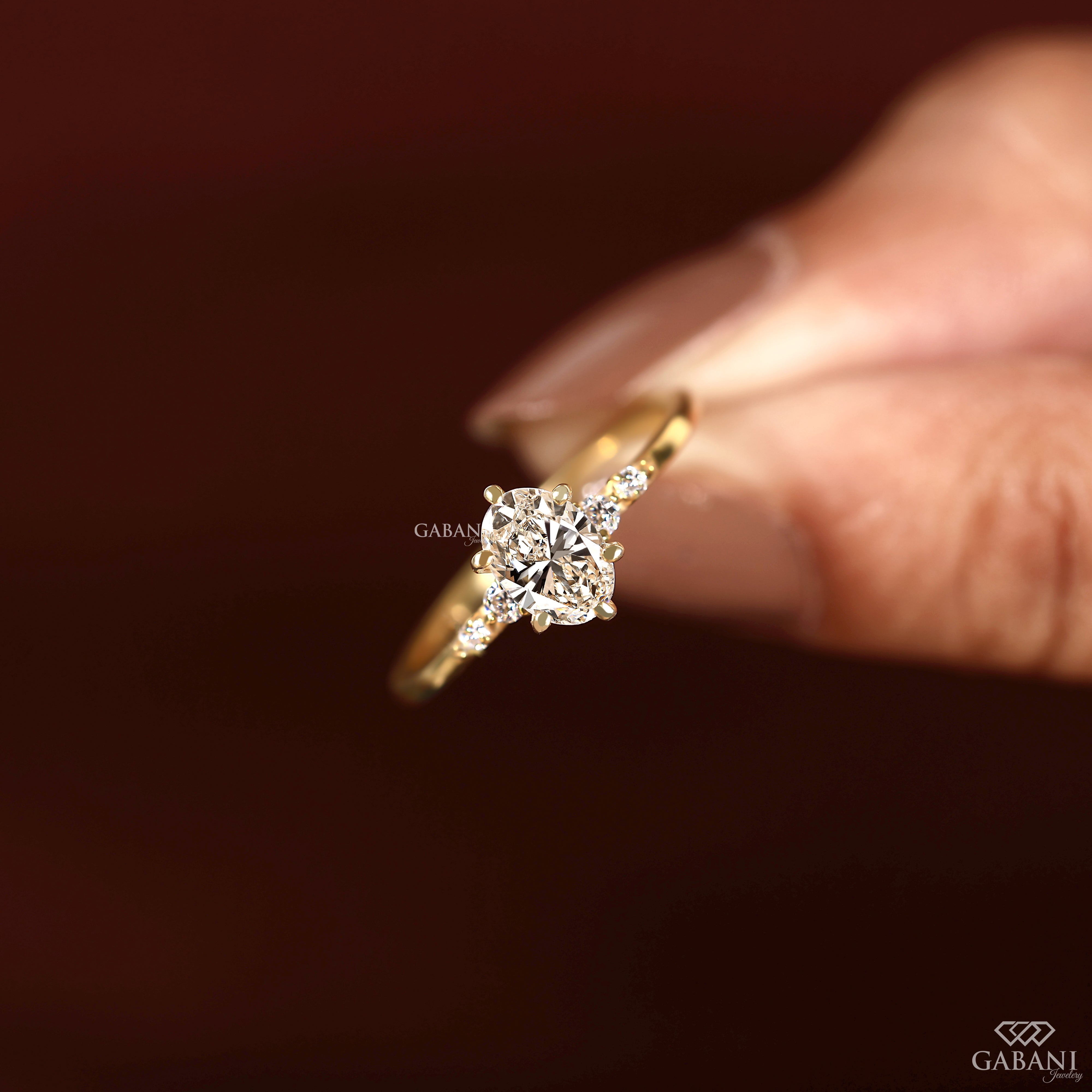 Oval cut lab grown diamond ring with round diamond shoulder accents