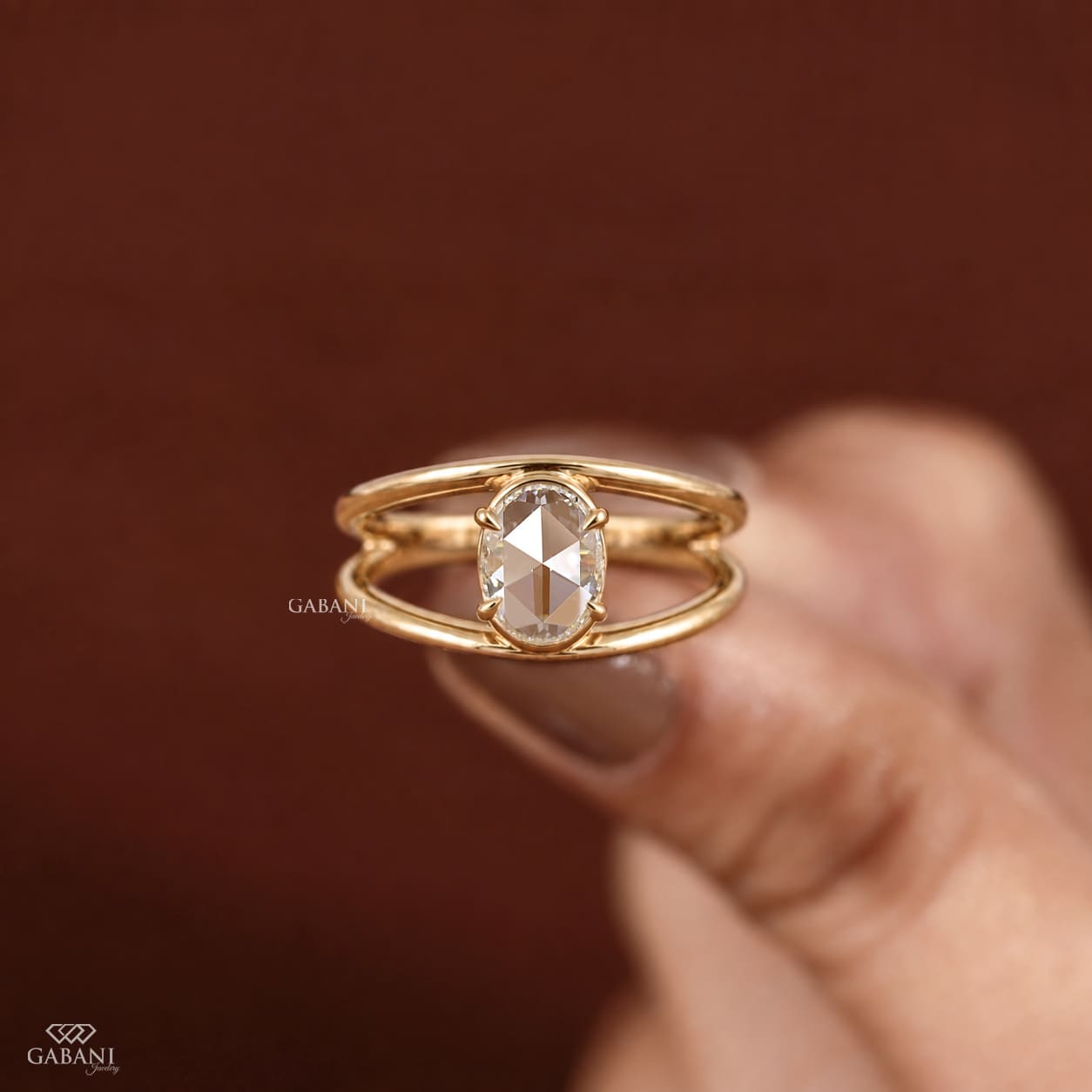 Oval rose cut lab grown diamond engagement ring with prong setting, open split shank design and polished yellow gold band.