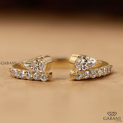 pear cut lab grown diamond open cuff ring showing the partial bezel settings, open ends and polished yellow gold band.