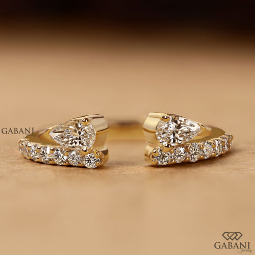 pear cut lab grown diamond open cuff ring showing the partial bezel settings, open ends and polished yellow gold band.