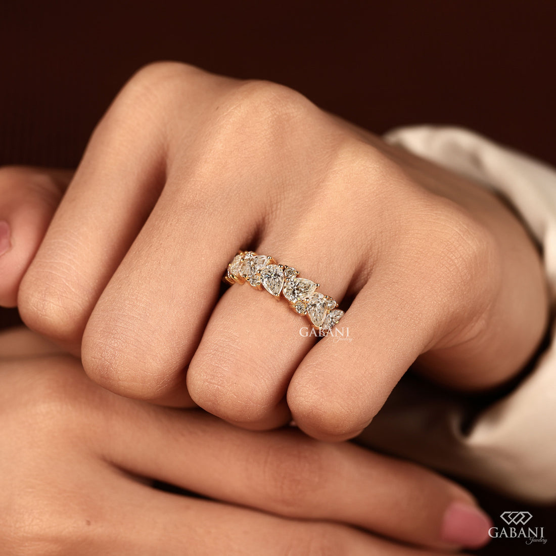 Pear and round lab grown diamond half eternity wedding band in yellow gold with alternating prong set diamond design.