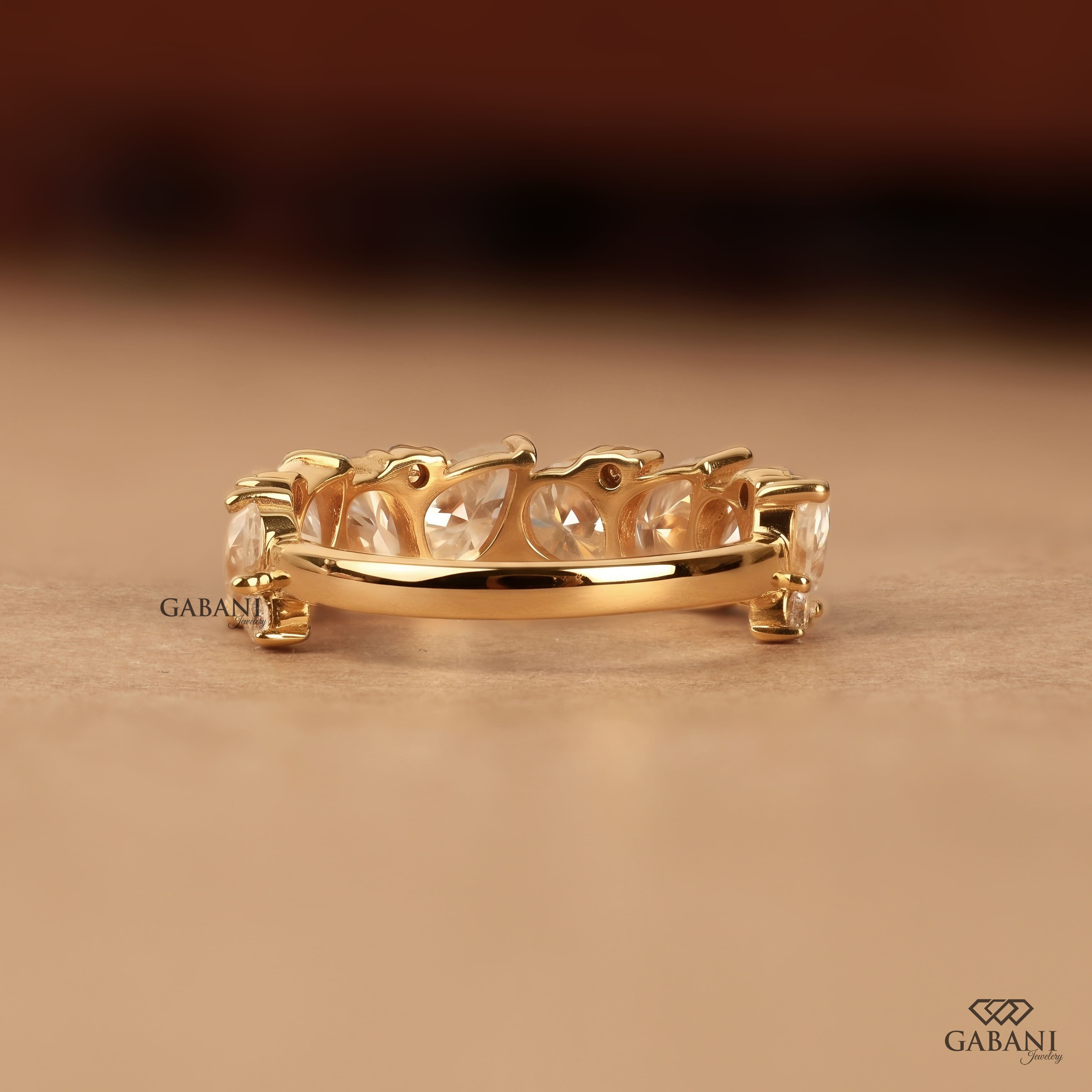 Pear and round lab grown diamond half eternity wedding band in yellow gold with alternating prong set diamond design.
