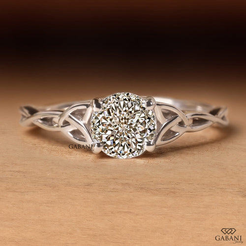 Portuguese cut lab grown diamond engagement ring with four-prong setting and nature-inspired open leaf vine white gold band.