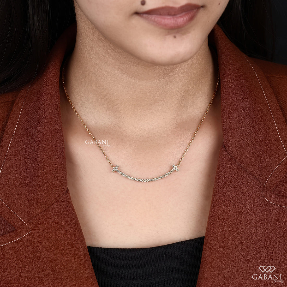 Curved bar lab grown diamond necklace in yellow gold featuring round pavé set diamonds, T-shaped ends and a delicate gold chain.