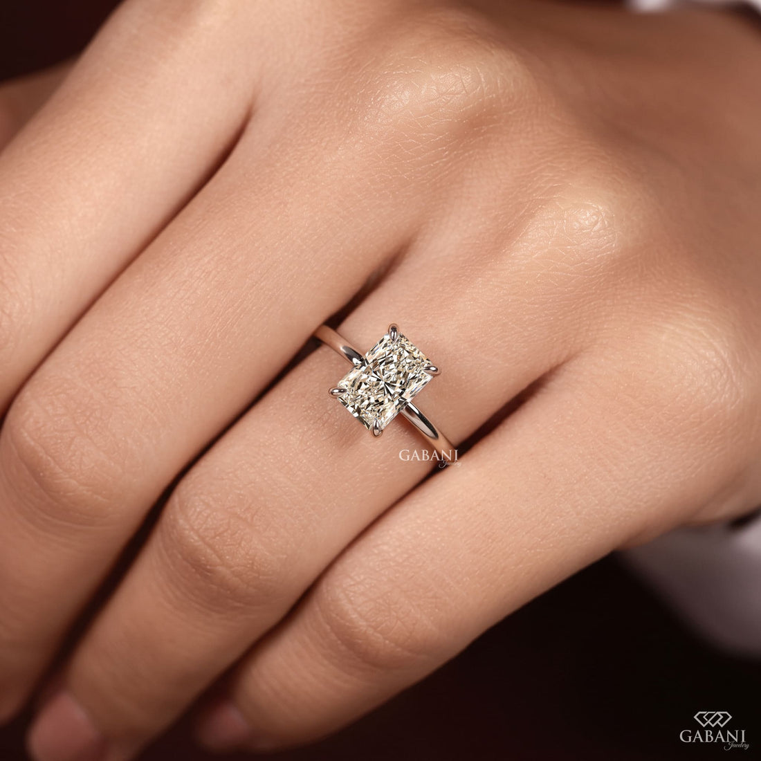 Radiant cut lab grown diamond solitaire engagement ring in 18K white gold with a classic four claw prong setting and polished band.